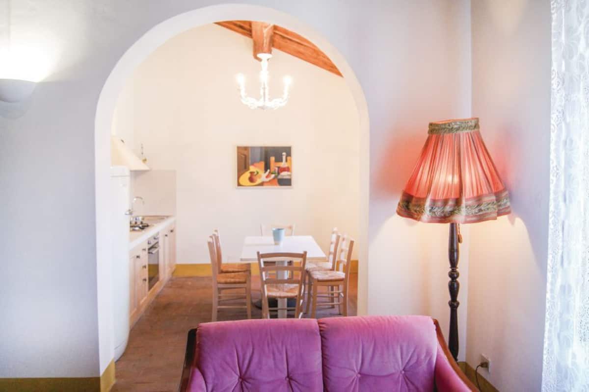 Ein Essbereich mit Tisch und Stühlen, einer Pendelleuchte und einer Lampe.