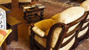 Un salon traditionnel avec une cheminée, des meubles en bois et un lustre.