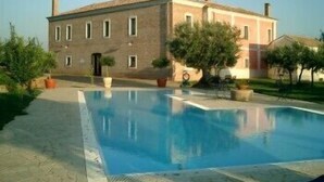 A large building with a swimming pool, surrounded by greenery and trees. - Le Carolee (Pianopoli)