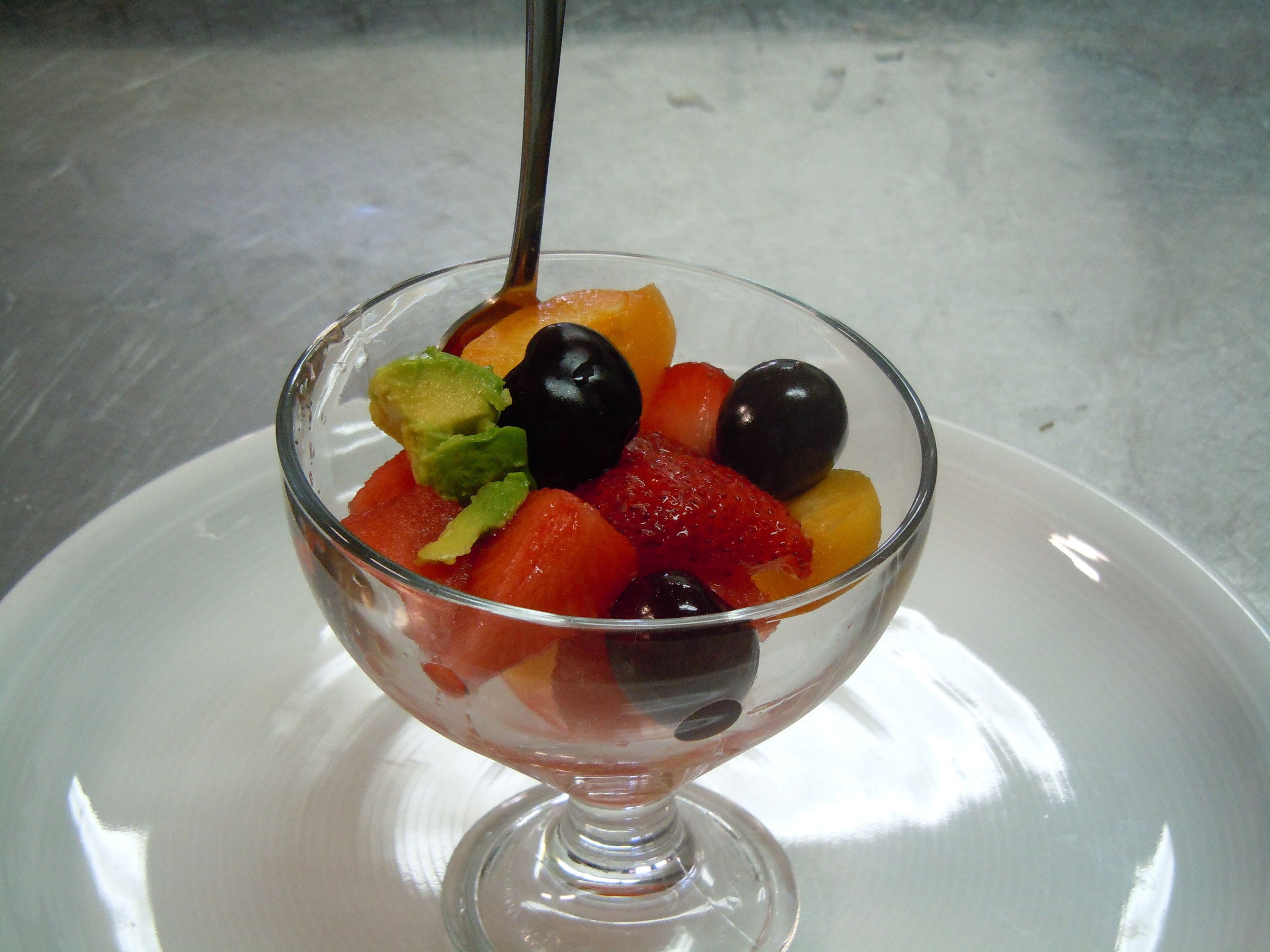 A dessert in a glass bowl on a white plate.