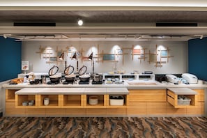 A modern kitchen area with a long counter, various kitchen appliances, and storage cabinets. - Dotonbori Hotel (Osaka)