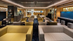 A hotel lobby with seating areas, a reception desk, and a bar. - Dotonbori Hotel (Osaka)