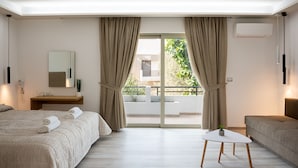 A modern hotel room with a large bed, a small table, a sofa, and a balcony with curtains. - Terinikos Sunny Garden Hotel & Junior Suites (Rhodes)