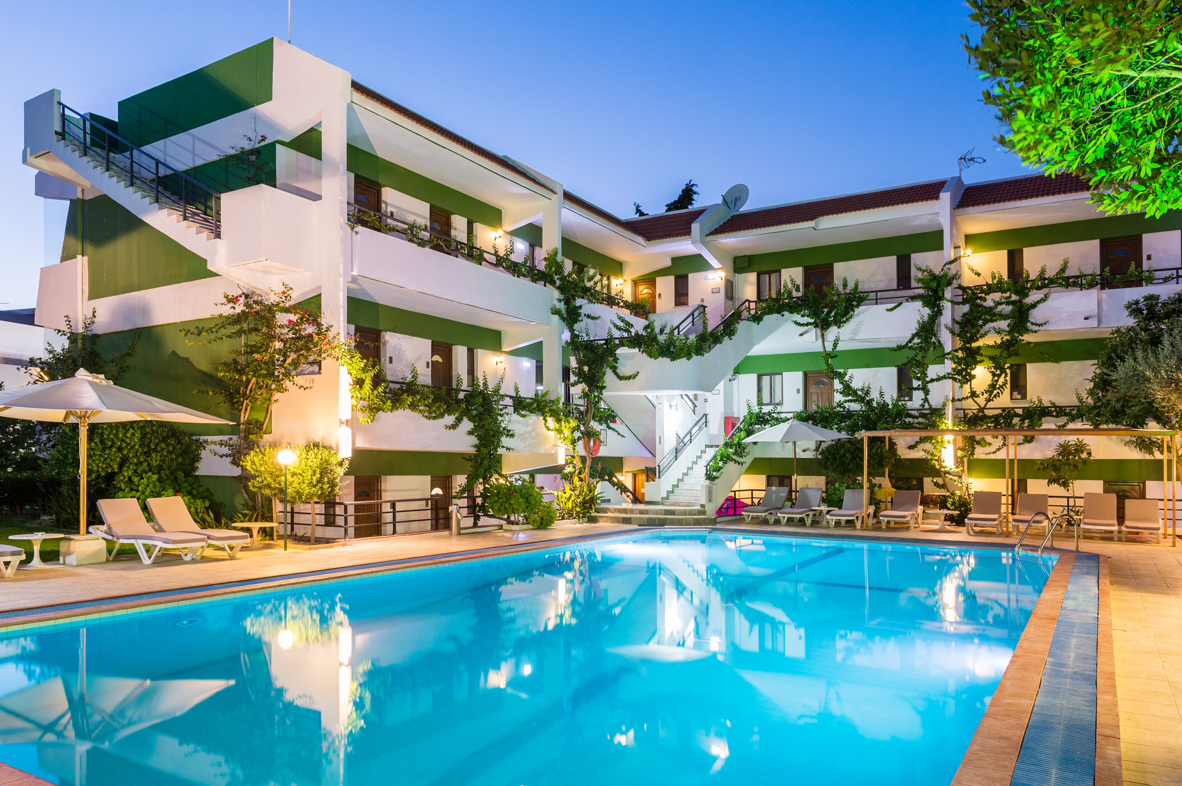 Un hôtel doté d’une piscine, d’un espace extérieur aménagé et d’un escalier menant aux étages supérieurs.