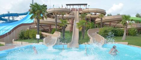 Un parque acuático con múltiples toboganes y una zona de piscina.