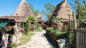 Un pueblo rural con chozas de techo de paja y un sendero de tierra.