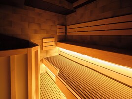 Una sauna con bancos de madera y piso de baldosas.