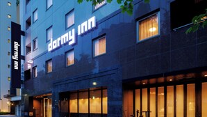 Un hotel con fachada moderna, amplias ventanas y una entrada destacada.