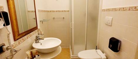 A bathroom with two sinks, a toilet, and a shower.