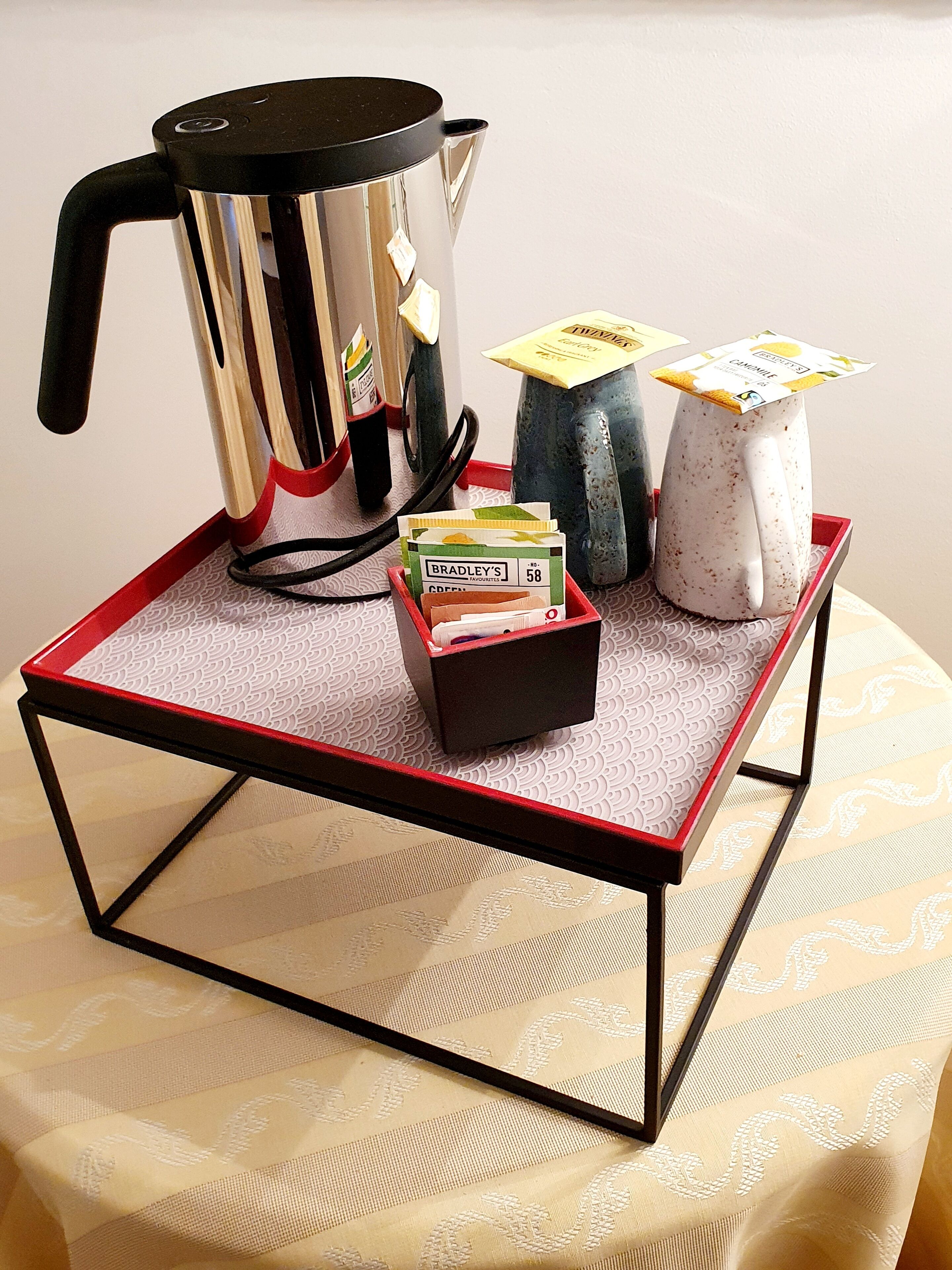 A coffee maker, a box of coffee pods, and a mug on a tray.