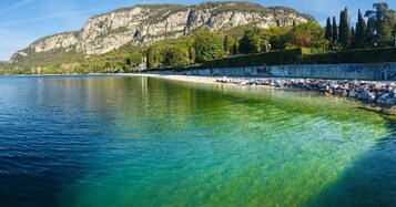 Una piscina al aire libre, sombrillas, sillones reclinables de piscina