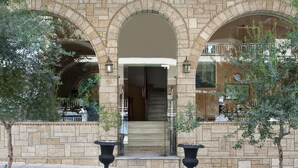 A building with a stone facade, arched entrance, and a staircase leading to an upper level. - Boutique Elizabeth Hotel (Athens)