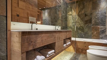Een moderne badkamer met een houten wastafelmeubel, een glazen douchecabine en een wit toilet.