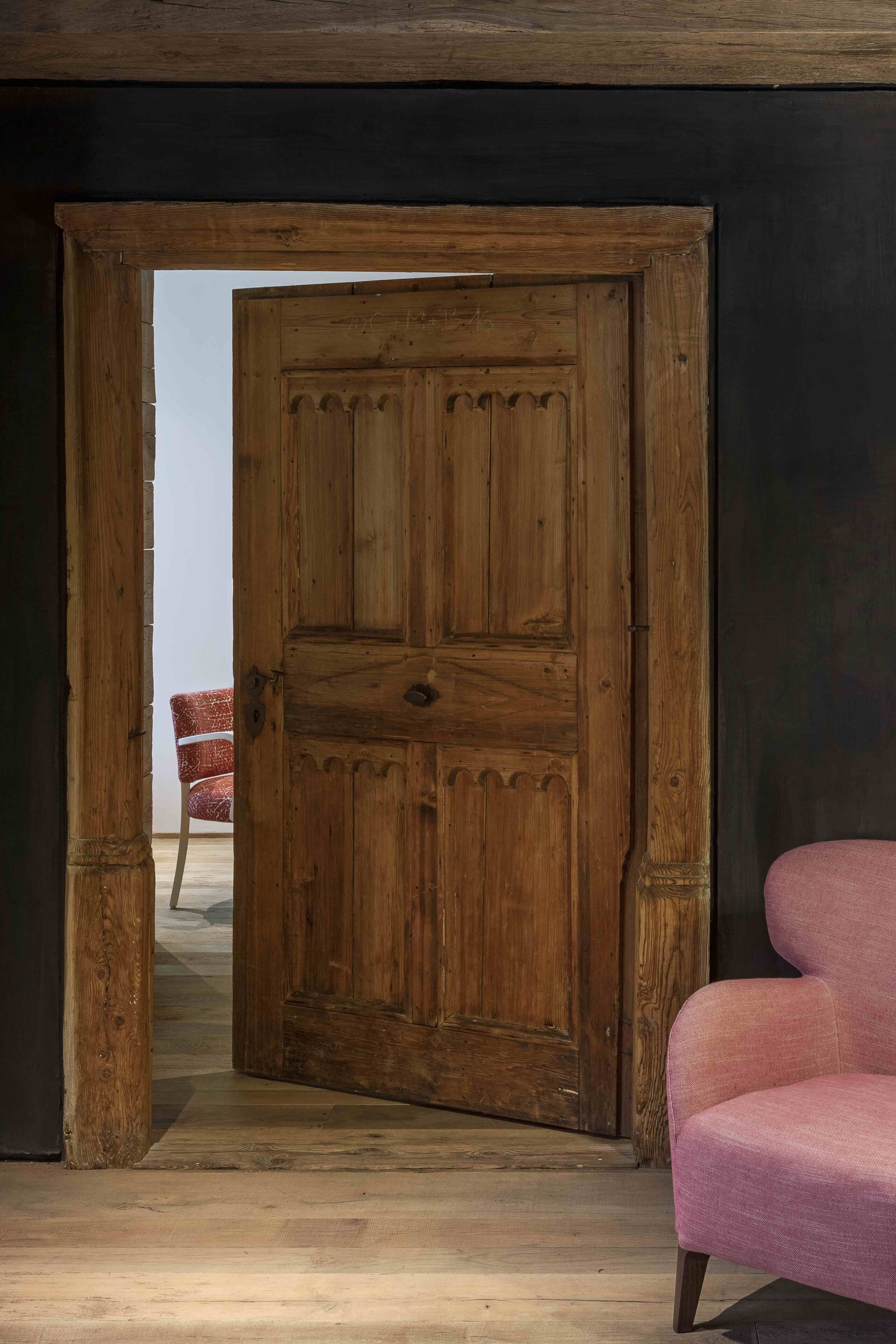 A wooden door with a chair in the background.