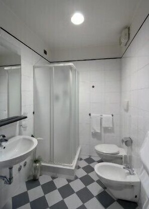 A bathroom with a shower, two sinks, and a toilet. - Antica Locanda Il Sole (Castel Maggiore)