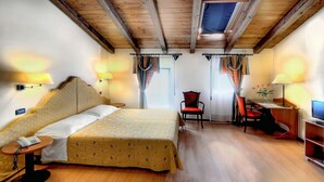 A hotel room with a bed, a desk, a chair, and a television. - Antica Locanda Il Sole (Castel Maggiore)