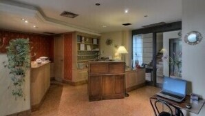 A room with a wooden desk, a laptop, a chair, a bookshelf, and a plant. - Antica Locanda Il Sole (Castel Maggiore)