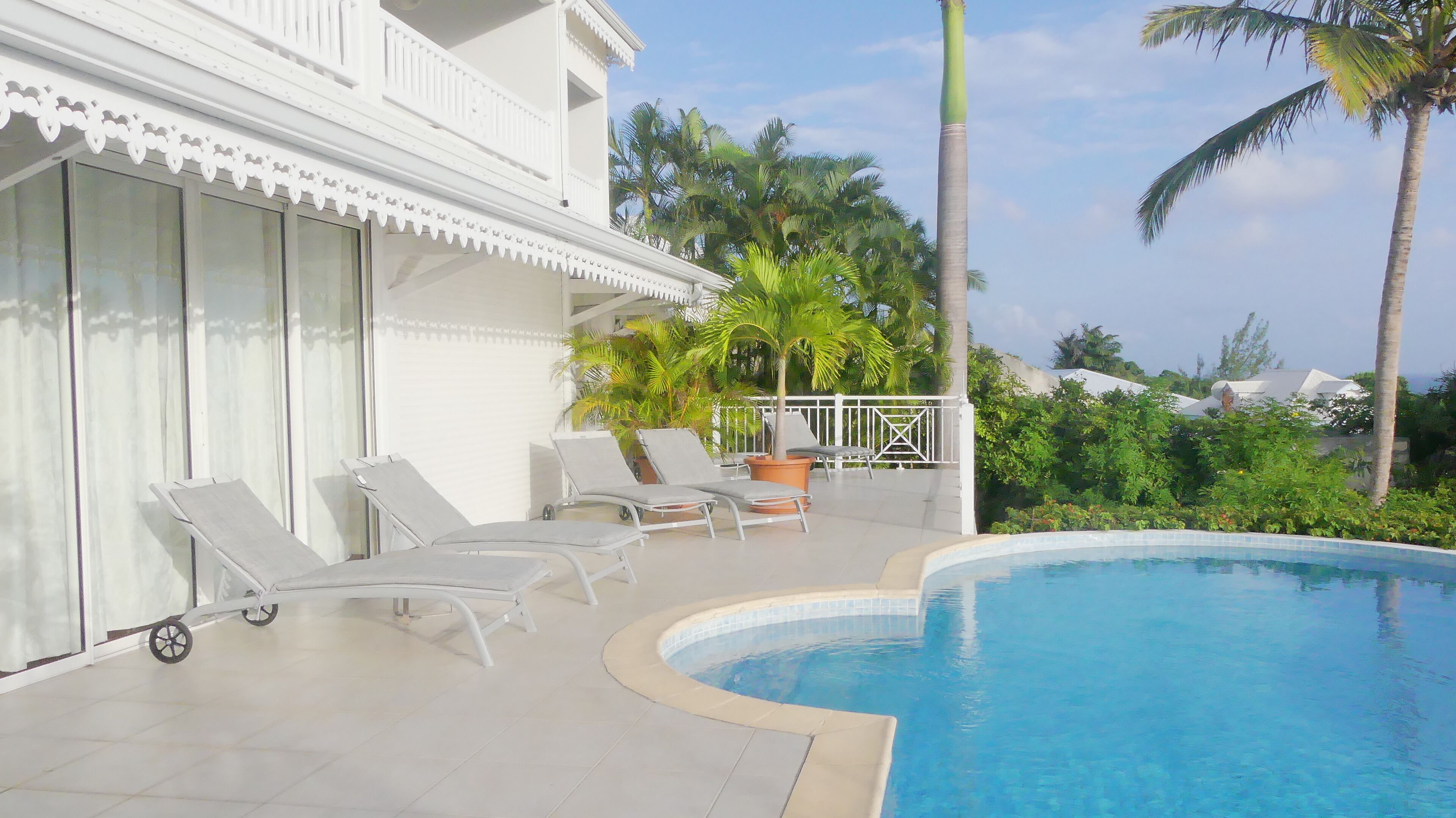 A poolside area with lounge chairs and a pool.