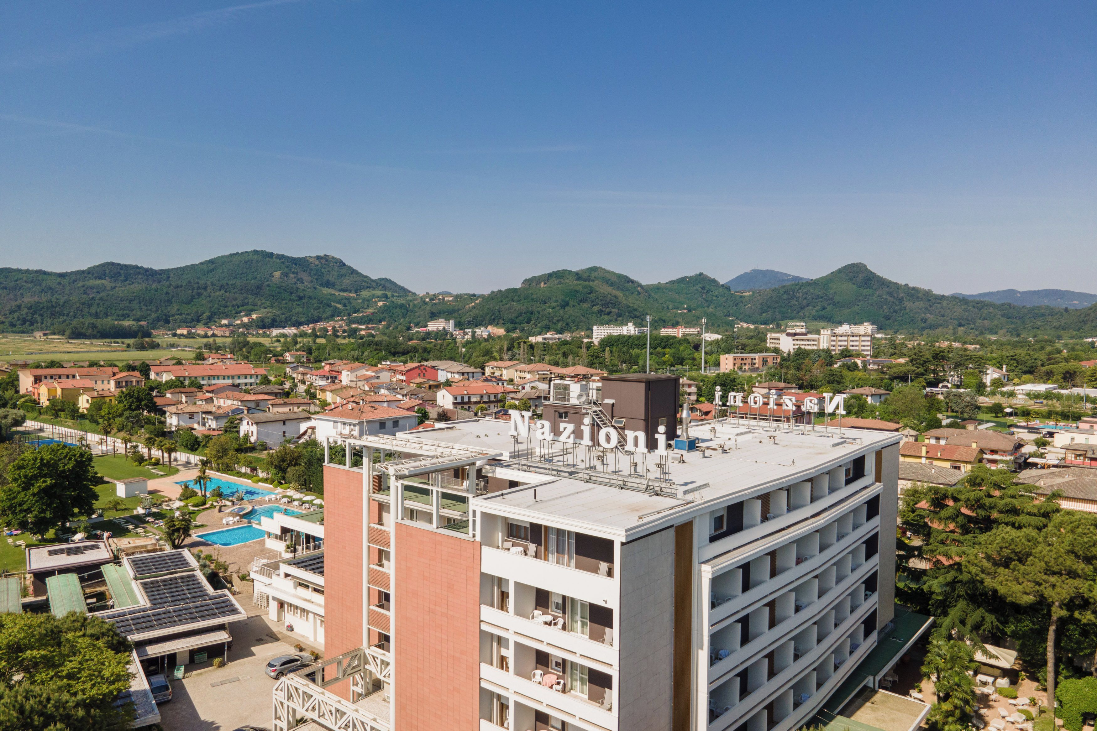 A multi-story hotel with a rooftop pool and solar panels.