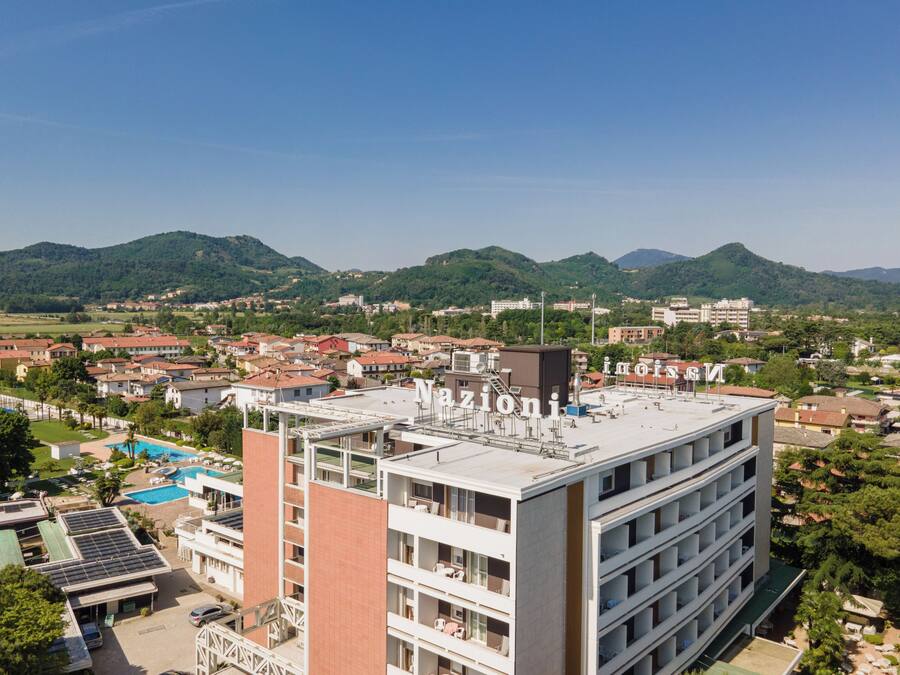 A multi-story hotel with a rooftop pool and solar panels.