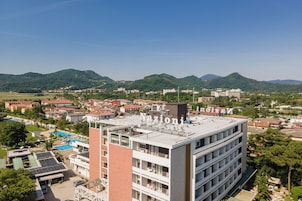 Un hotel de varios pisos con piscina en la azotea y paneles solares.