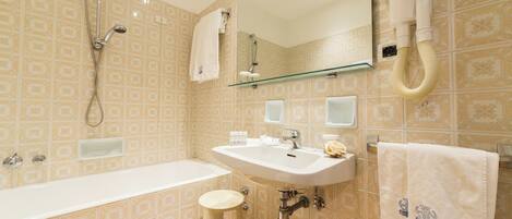 A bathroom with a bathtub, sink, and a mirror.