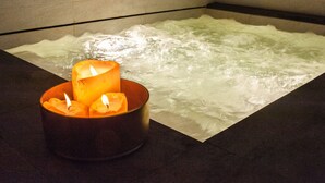 Une baignoire avec une bougie dans un récipient.