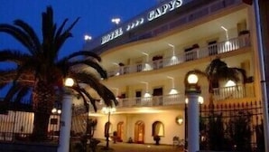 A multi-story hotel with balconies and a well-lit entrance. - Capys (Capua)