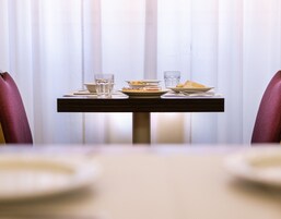 Un tavolo da pranzo con piatti, bicchieri e un tovagliolo.