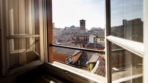 A view from a window overlooking a cityscape with buildings and a tower. - Hotel Palace Bologna Centro (Bologna)