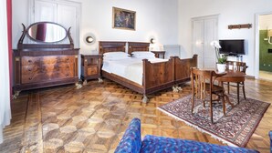 A bedroom with a wooden bed, dresser, and a television. - Hotel Palace Bologna Centro (Bologna)