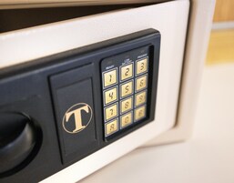 Een codekluis op een deur, met een T logo.