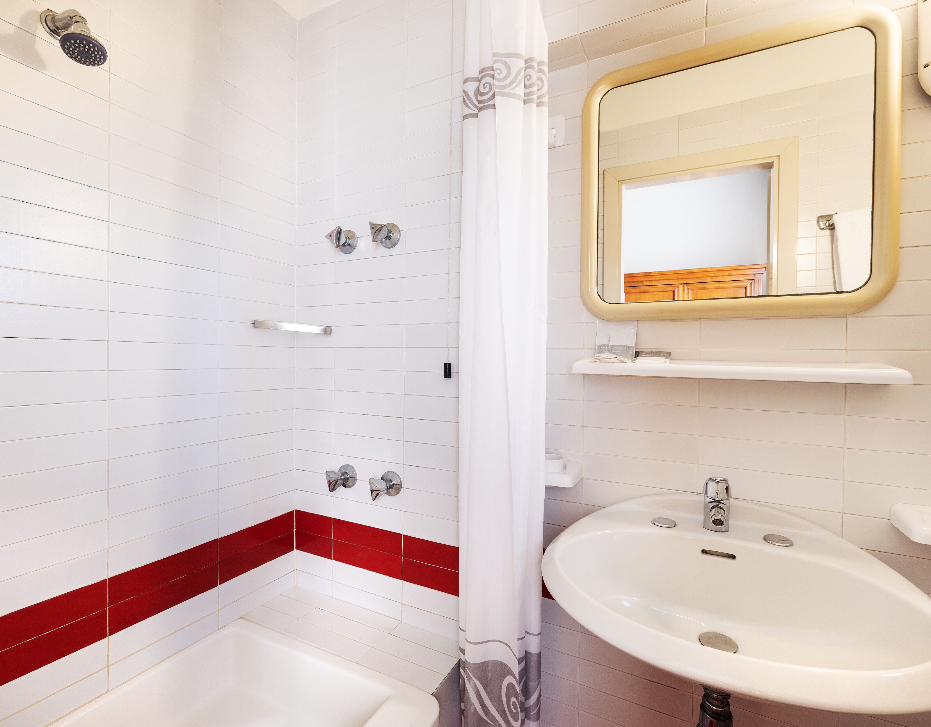 Ein Badezimmer mit Dusche, Waschbecken und Spiegel.