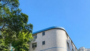 Un hotel con fachada curva, varias ventanas y un toldo azul.