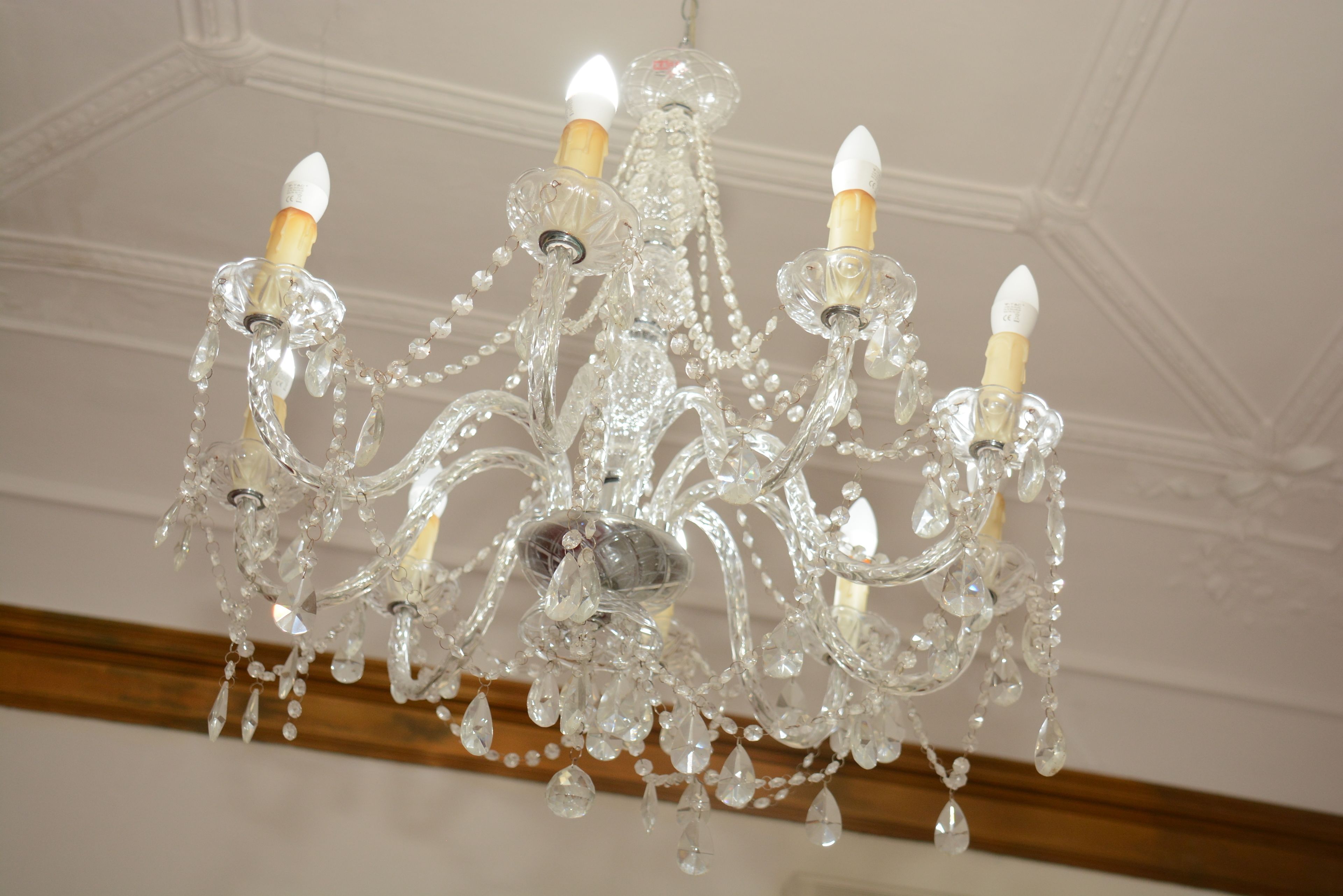 A chandelier with multiple arms and crystal decorations.