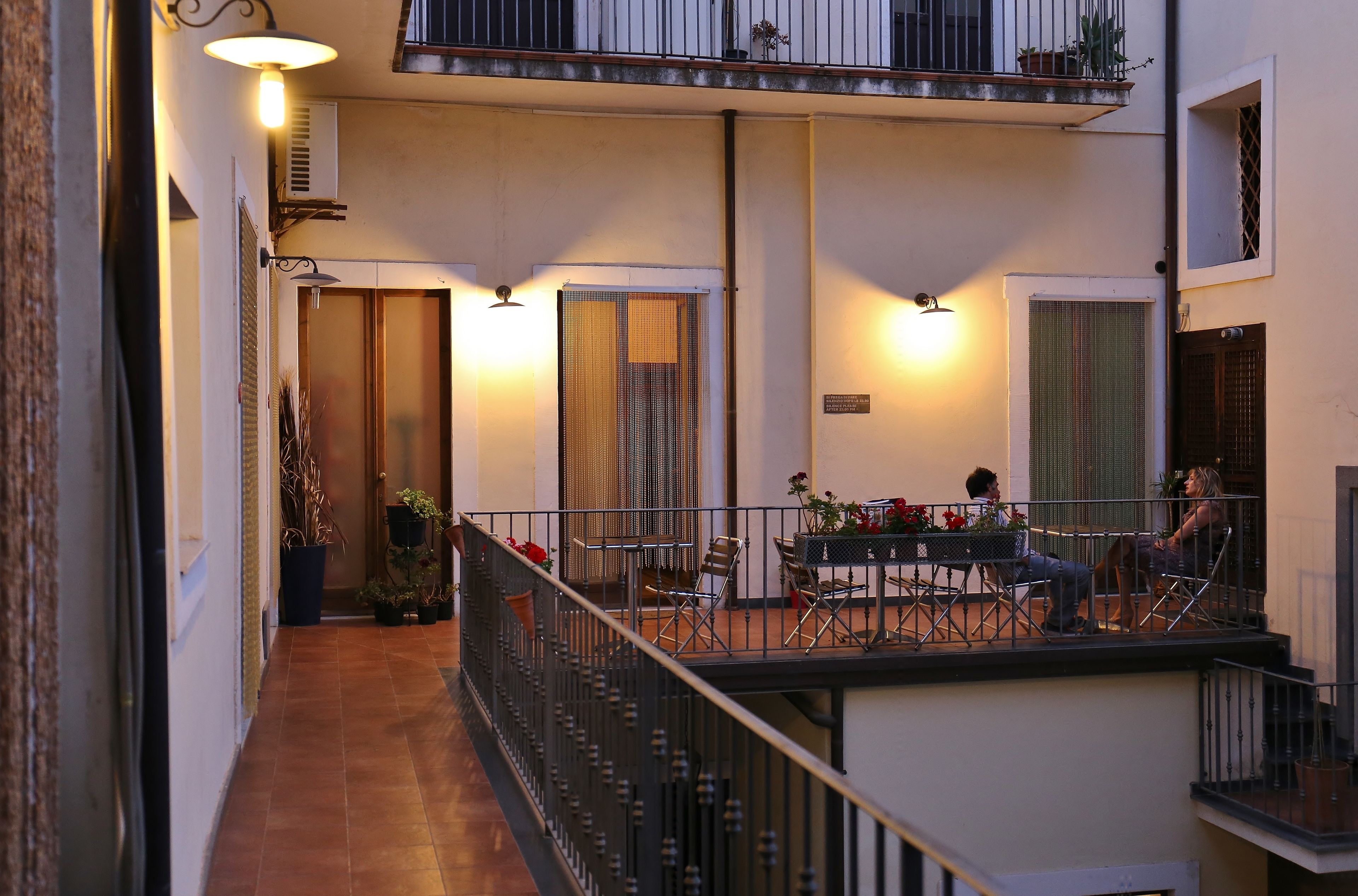 A balcony with outdoor seating, a staircase, and a view of the street.