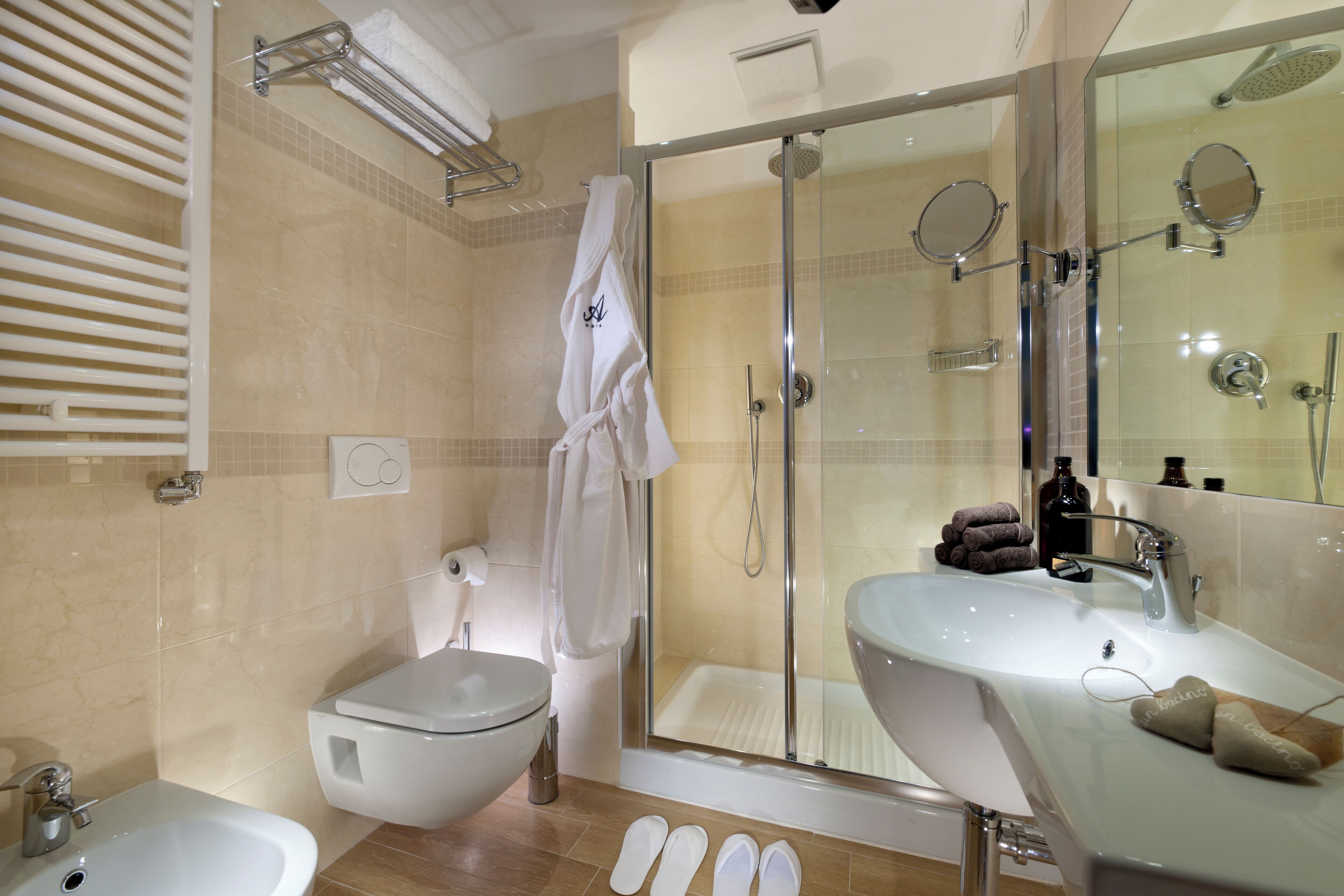 A modern bathroom with a glass-enclosed shower, a white sink, and a bidet.