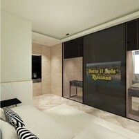 Un salón moderno con un gran ventanal corredera, un sofá, una mesa de centro y vista al mar.