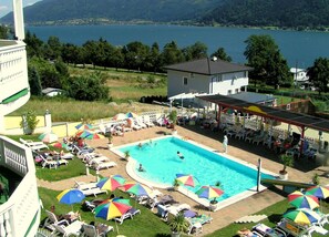 Una piscina al aire libre de temporada, sombrillas