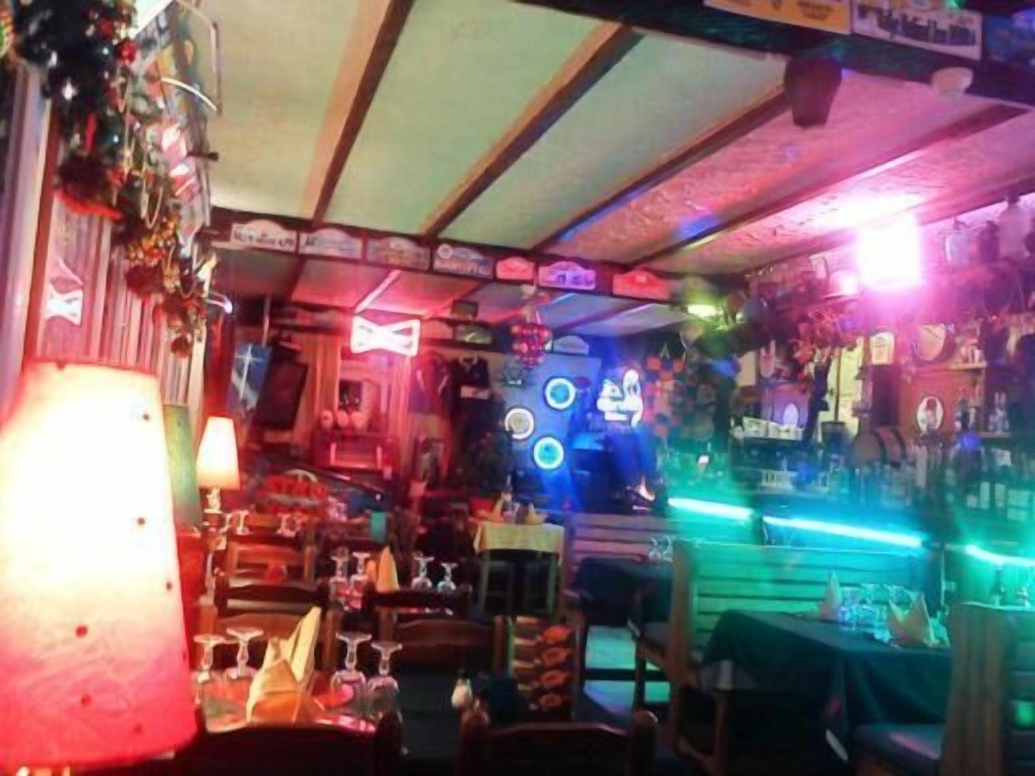Una habitación con una cama, una mesita de noche, una lámpara y una pared decorada.