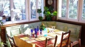 Un comedor con una mesa dispuesta para cuatro personas, rodeada de sillas de madera.