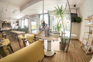 Un interno ristorante moderno, con soffitti alti, ampie finestre e un'isola centrale con una macchina da caffè.