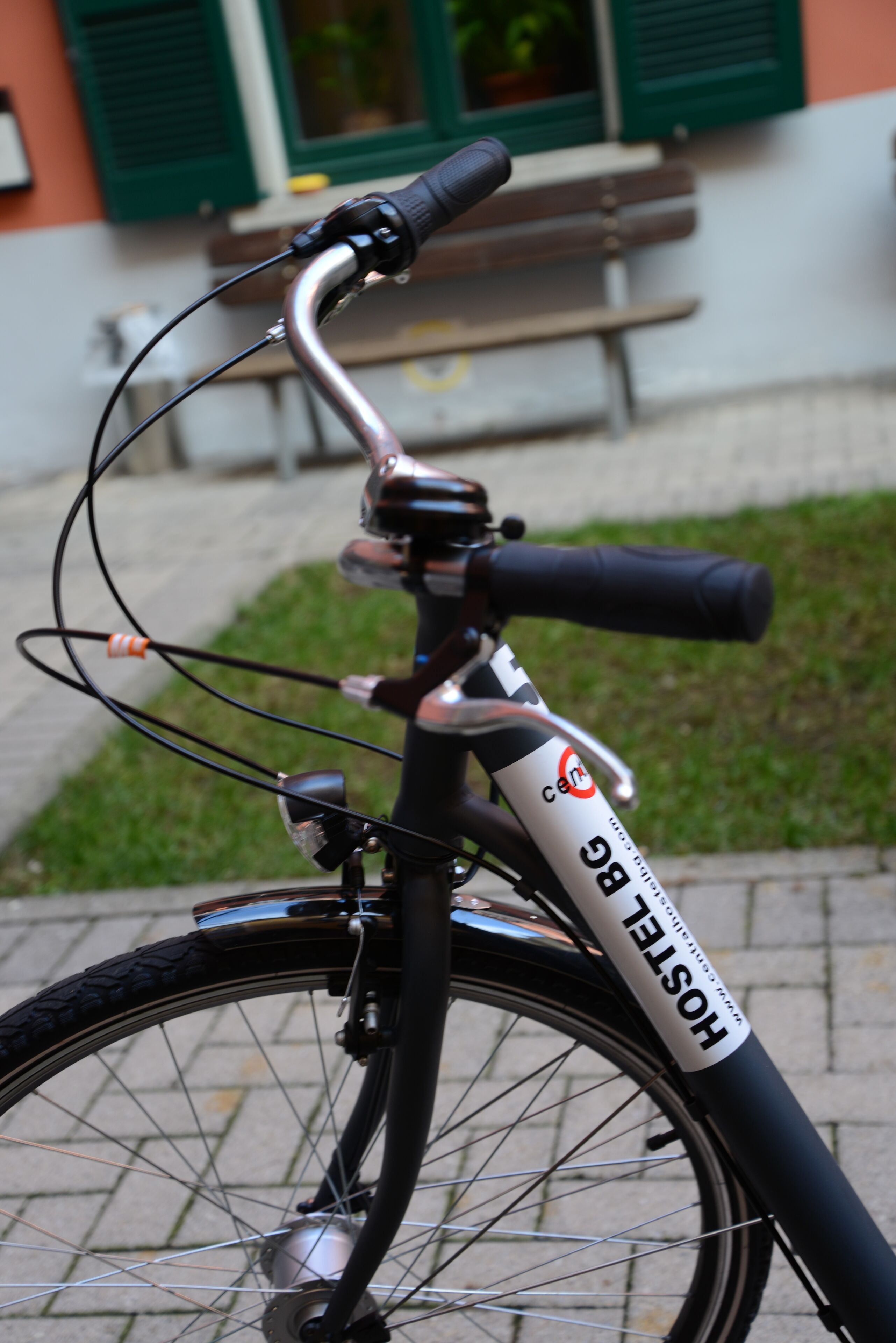 A bicycle with a "hostel" label, handlebars, and a front basket.