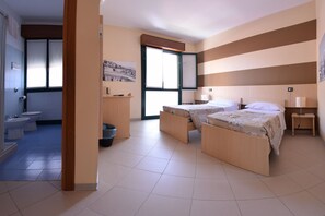 A modern hotel room with two single beds, a bathroom with a toilet and bidet, and a large window. - Central Hostel BG (Bergamo)