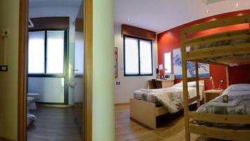 Ein Schlafzimmer mit Etagenbett, Nachttisch, Lampe und Fenster.