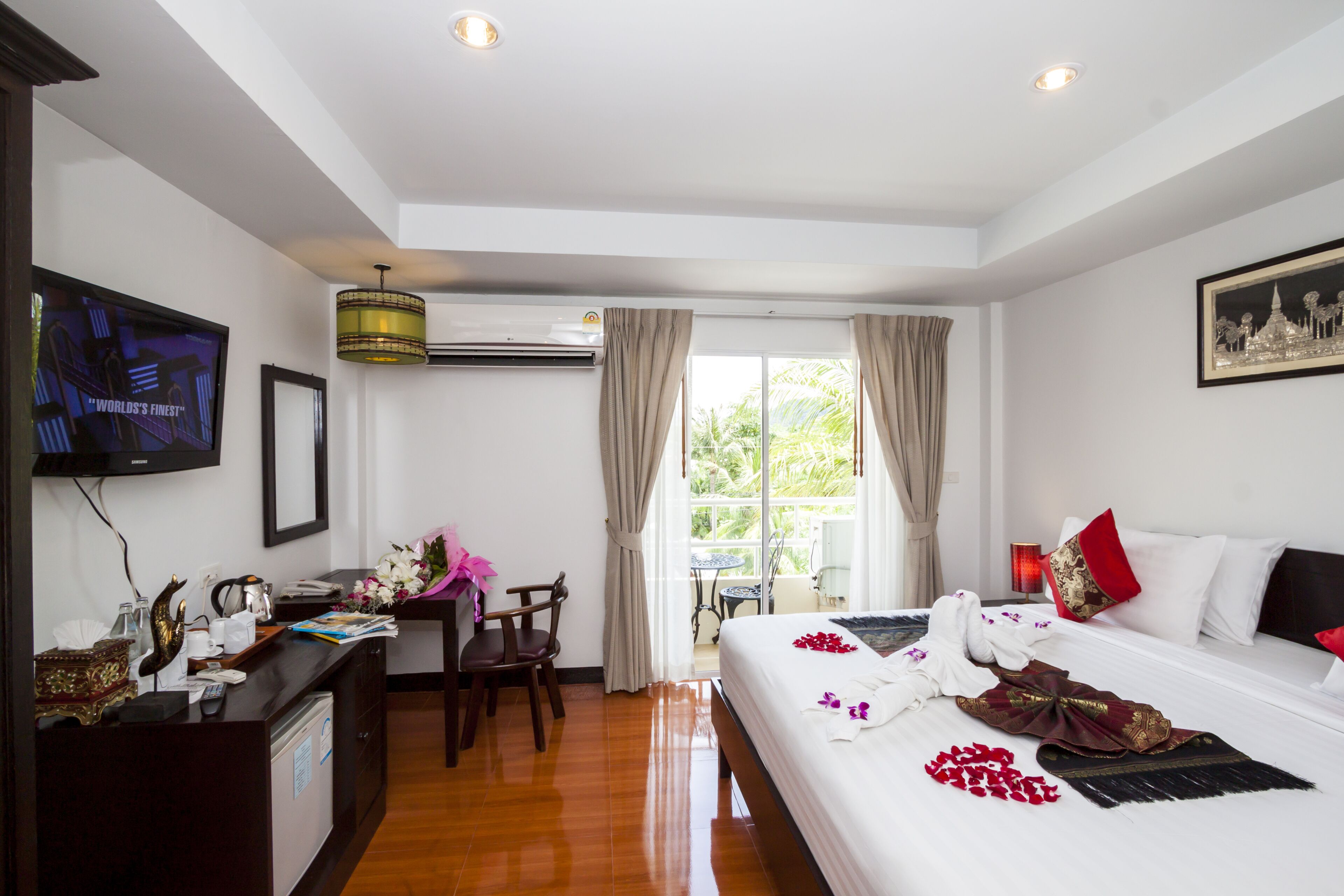 A hotel room with a bed, a desk, a television, and a window with curtains.