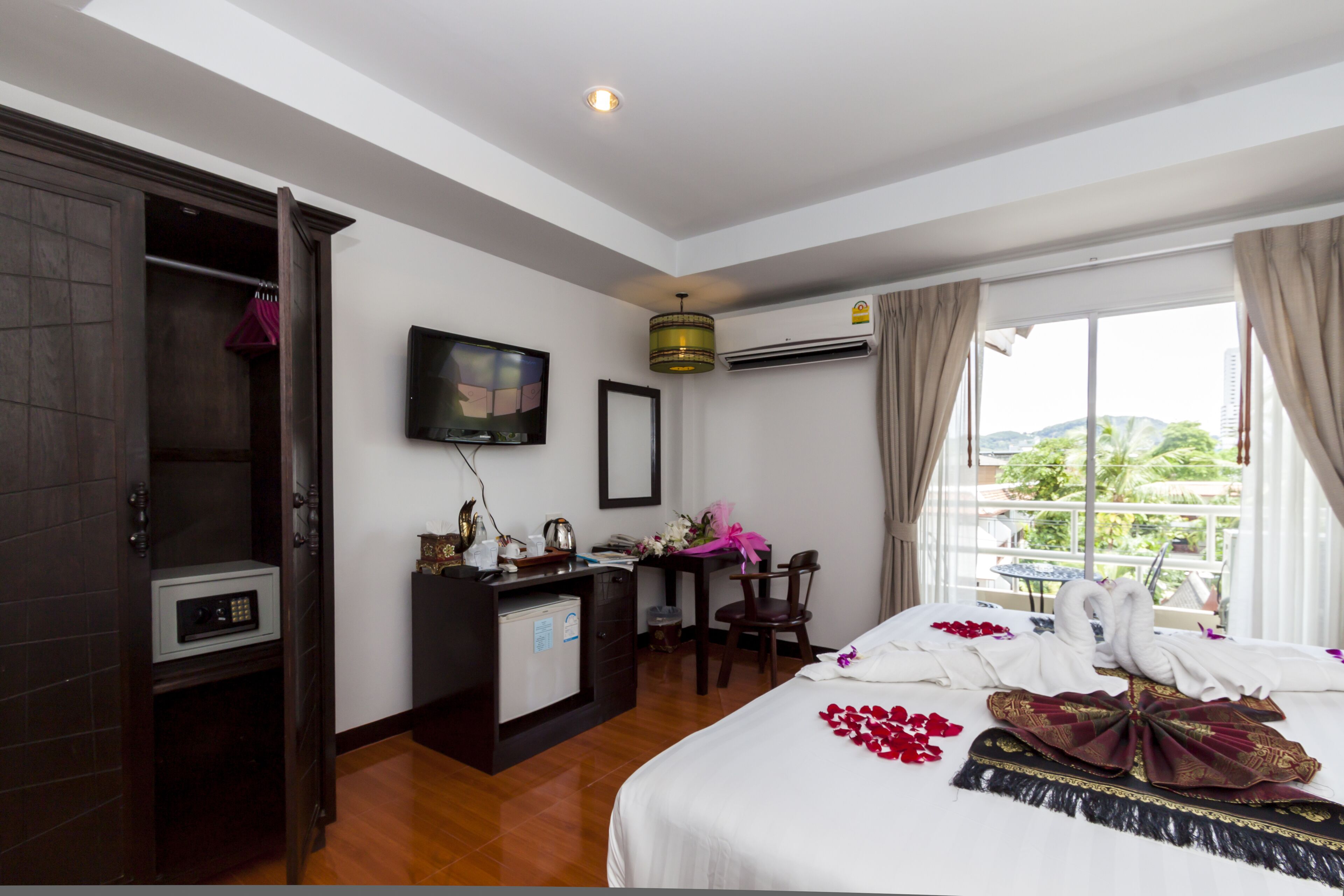 A hotel room with a bed, a desk, a TV, and a window with a view.