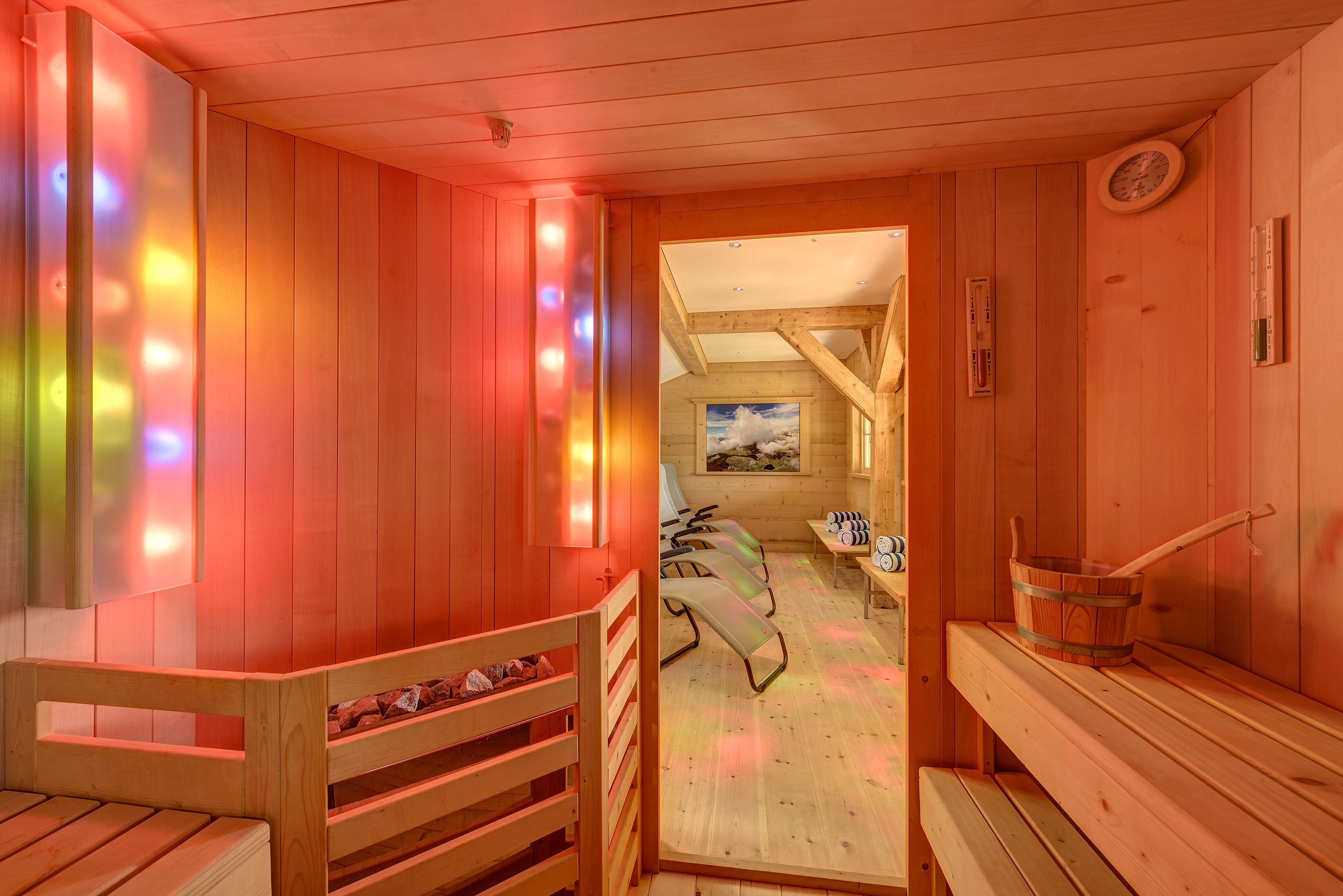 Un sauna en bois avec des bancs et un seau en bois.