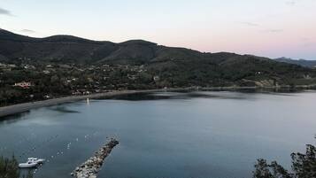 Un lago tranquilo con barcos, rodeado de colinas y un pequeño pueblo.