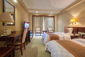 A hotel room with two beds, a desk with a chair, a television, and a lamp. - Xinzhou Haiwan Hotel (Shaoxing)